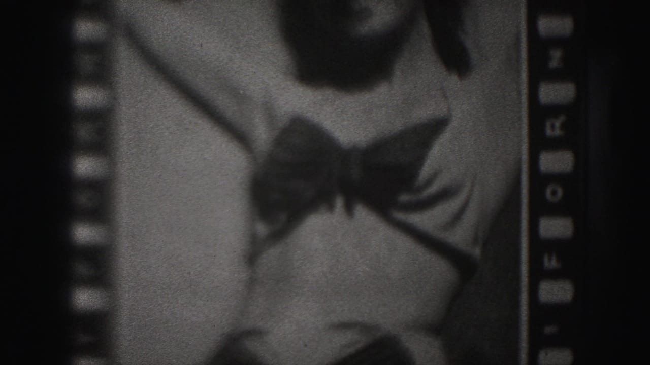 Close cropped black-and-white frame of a woman in a dark bikini posing on film stock.