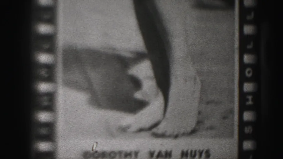 1975 Harrisburg 8mm frame with a soft poster close-up, bare feet, visible grain, and lower-edge lettering.