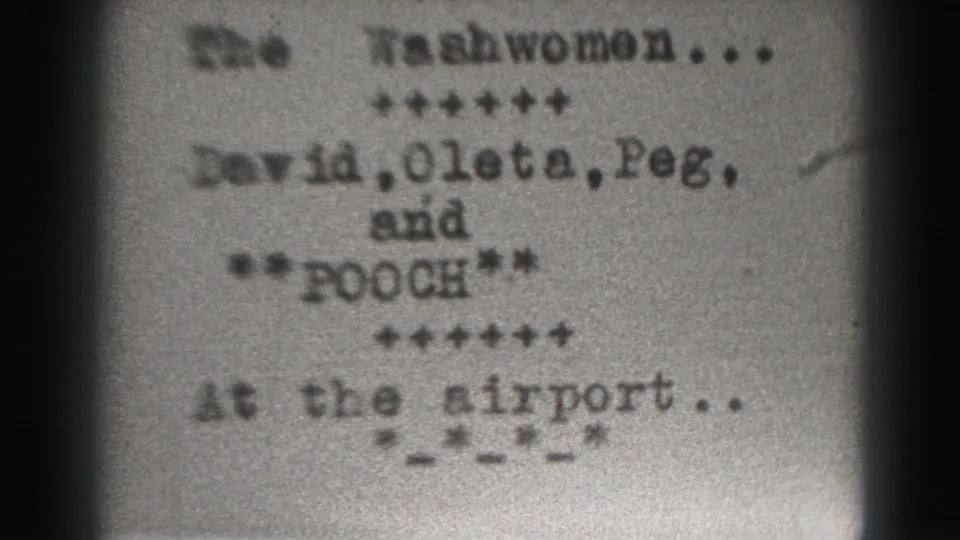 Soft 8mm frame from the Harrisburg 1975 reel showing the same typed The Washwomen card with cast names and at the airport text.