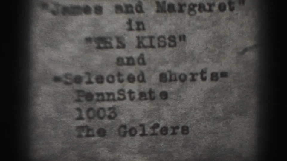 Grainy 1975 Harrisburg home-movie frame showing a typed program card for James and Margaret in The Kiss, selected shorts, Penn State 1003, and The Golfers.