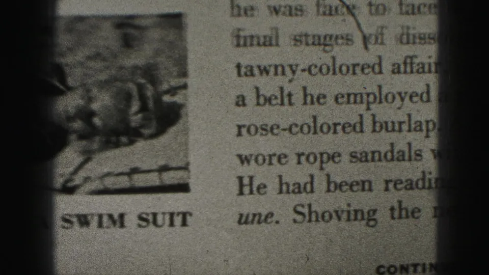 Close-up of a printed page showing text columns, a small swim-suit illustration, and the caption SWIM SUIT.