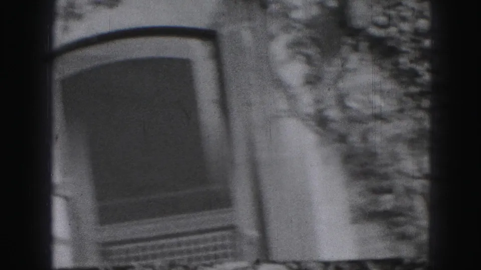 1975 Harrisburg home-movie frame showing an arched window beside dense ivy on an older building exterior.
