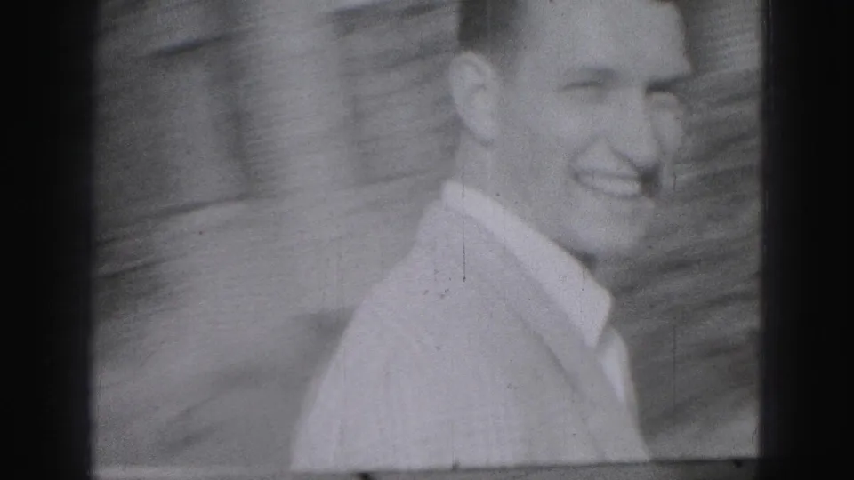 Smiling young man in a light collared shirt appears close to the camera in 1975 Harrisburg home-movie footage.