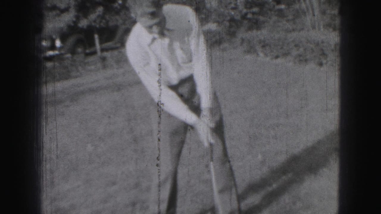 A young man in Harrisburg, Pennsylvania, appears to address or adjust a golf shot in grainy 1975 8mm footage.