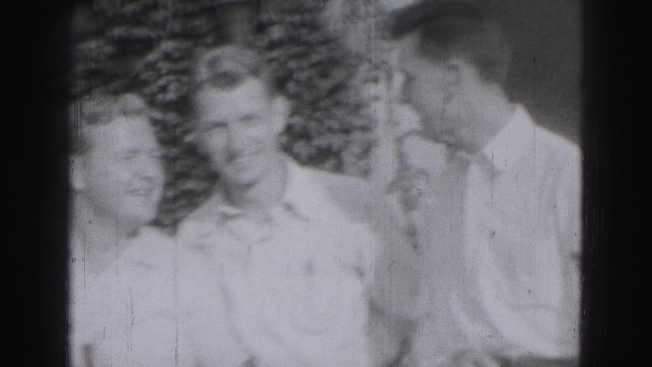 Three young men in light shirts stand outdoors near leafy background.