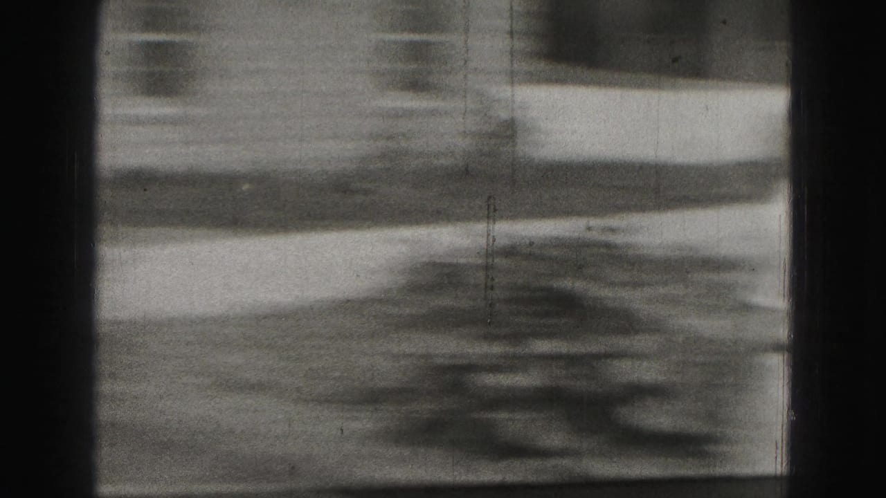 Soft, blurred 1975 8mm frame showing outdoor ground and building detail during camera movement in Harrisburg.