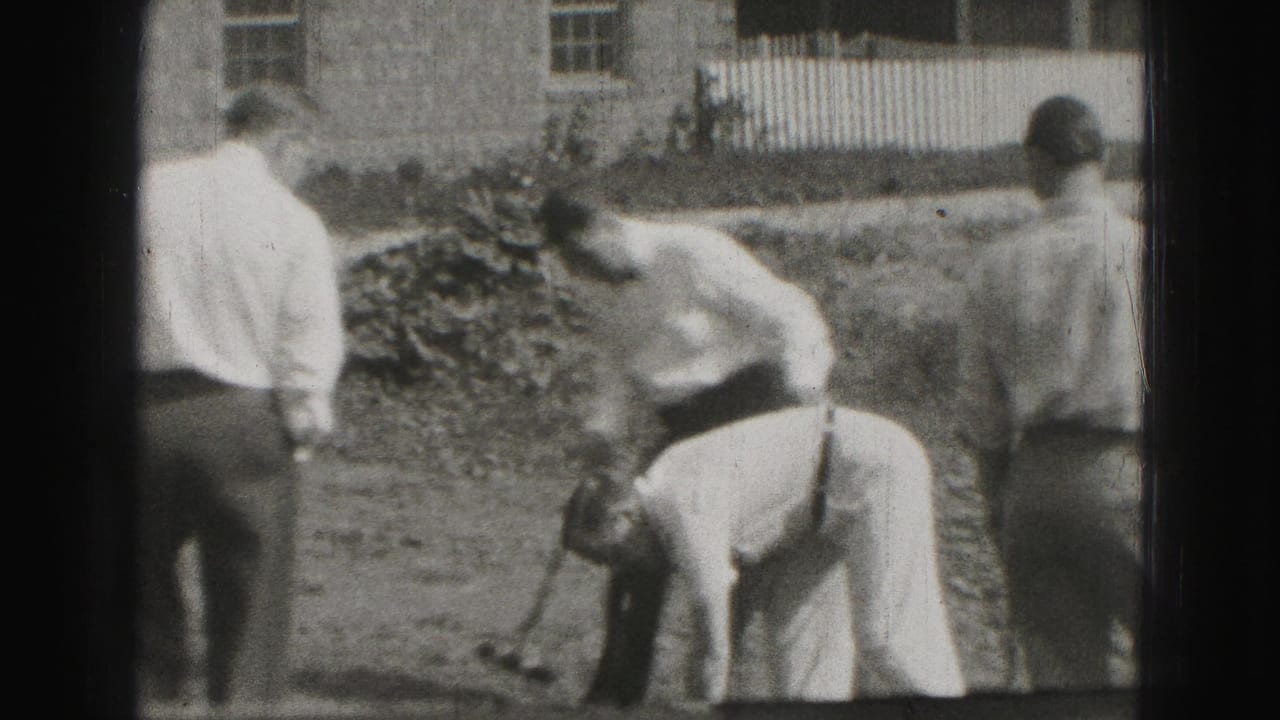 In Harrisburg 1975 home-movie footage, men in shirts and ties gather on a backyard lawn while one prepares near a croquet shot.