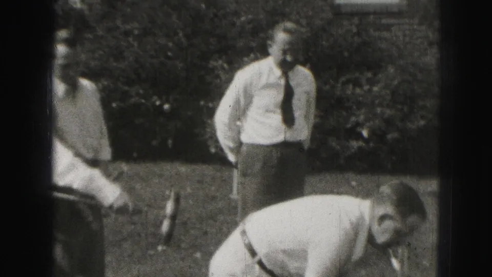 In the final frame, a man in a white shirt and dark tie watches while another player bends over the backyard croquet play.
