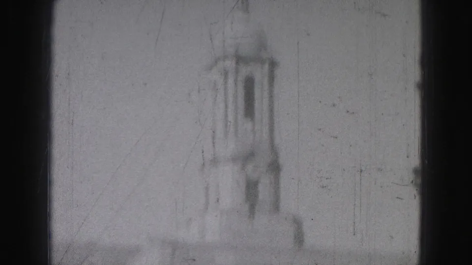 Brief soft-focus 1975 Harrisburg home-movie view of a distant tower, with no identifying landmark confirmed.