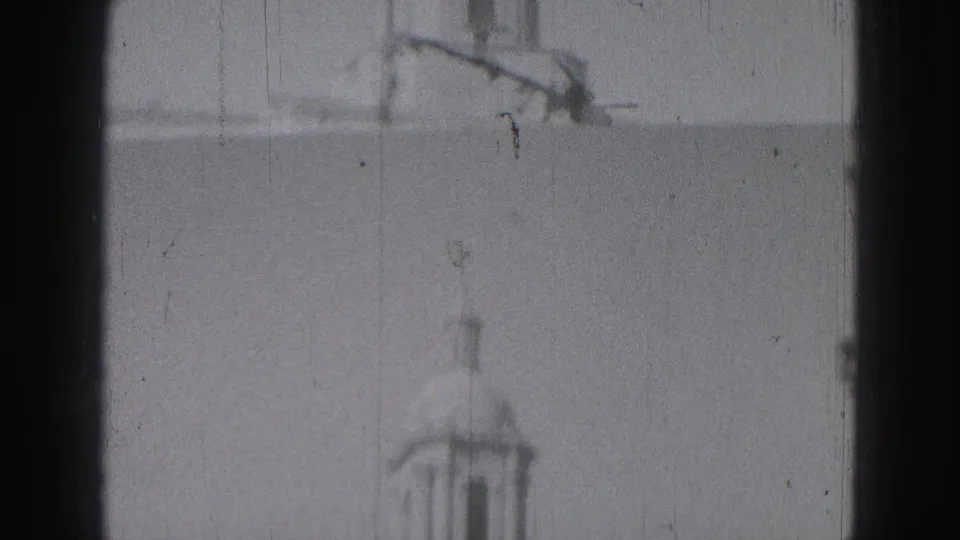Blurred 8mm frame of the upper tower area and pale facade, with Harrisburg location supported by clip metadata.