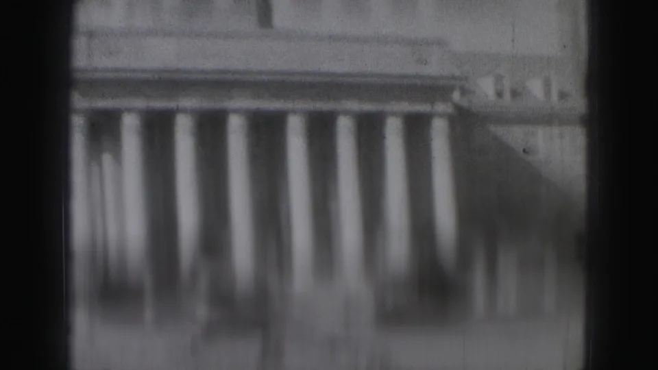 Soft 8mm view of a large white colonnade in Harrisburg, heavily blurred and partly obscured.