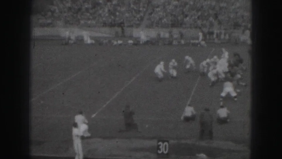 1975 Harrisburg home-movie view of a football play near the 30-yard line, seen from high in the stadium stands.