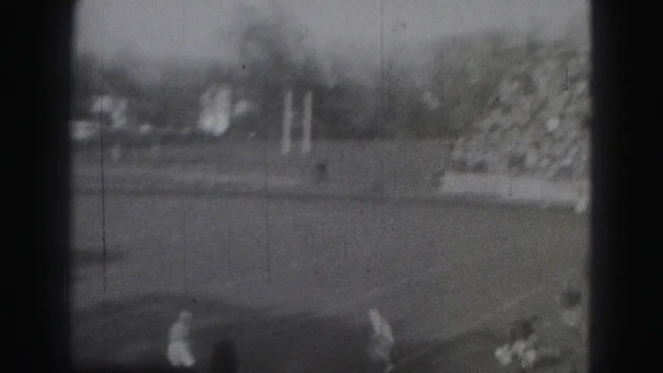 1975 Harrisburg home-movie frame showing a distant football field, goalpost, and blurred players from the stands.