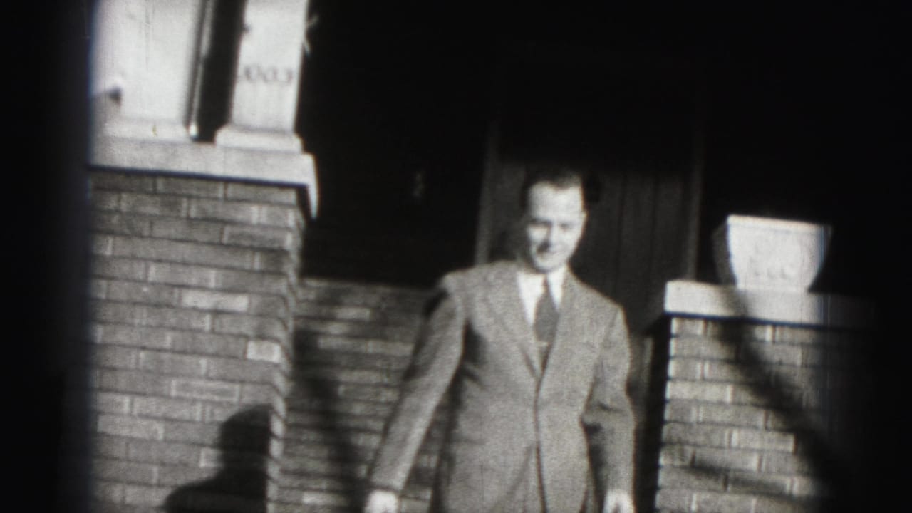 The Harrisburg 8mm frame shows a smiling suited man moving toward the camera from a brick entryway.