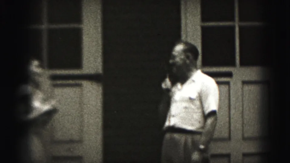 Near the end of the Harrisburg 8mm clip, the man looks to the side while holding the microphone outside the building.