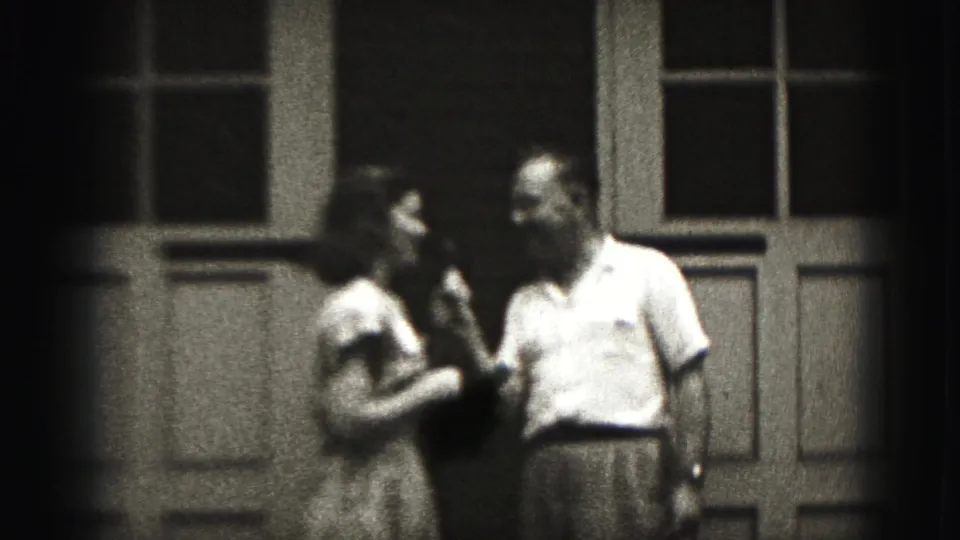 A man and girl face one another during an informal microphone exchange outside a Harrisburg house in 1975 footage.