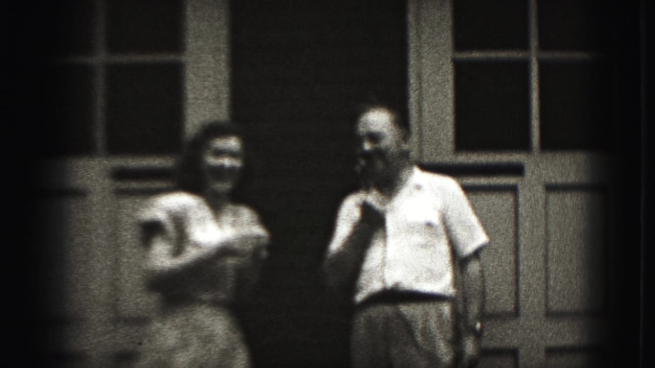 The woman appears to laugh or speak into the shared microphone while the man stands nearby in Harrisburg, Pennsylvania footage from 1975.