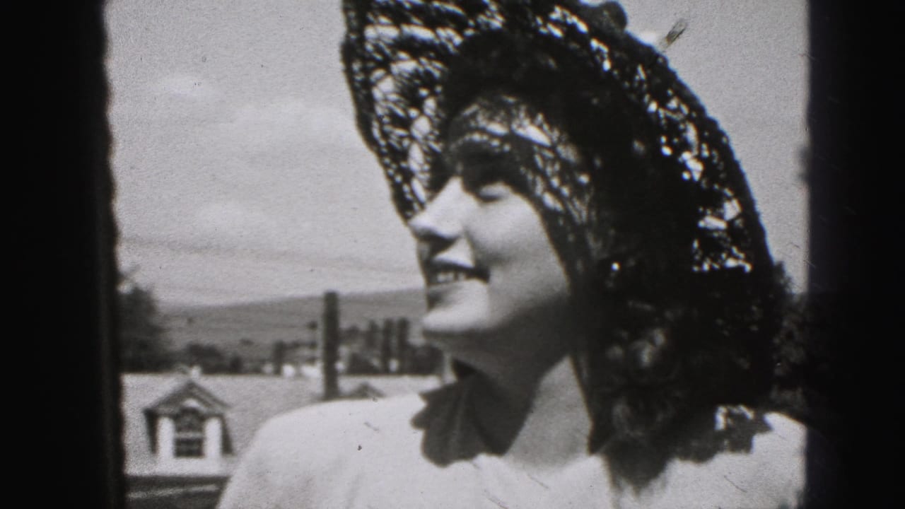 Young woman in a wide lace sun hat smiles in profile outdoors.