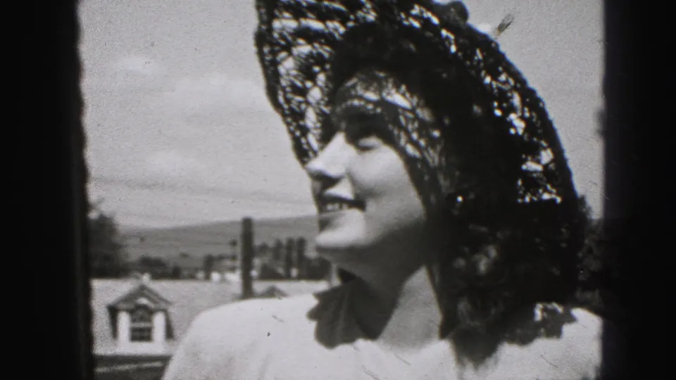 Young woman in a wide lace-style sun hat smiles in profile outdoors, Harrisburg, Pennsylvania, 1975 home-movie footage.