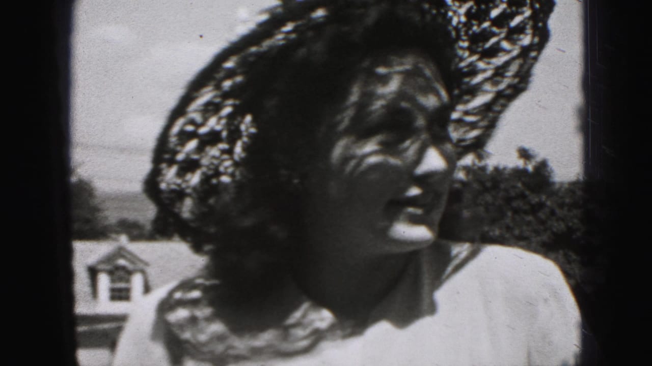 A woman in Harrisburg, Pennsylvania home-movie footage wears a wide lace hat and light dress, her face partly shadowed as she looks left.