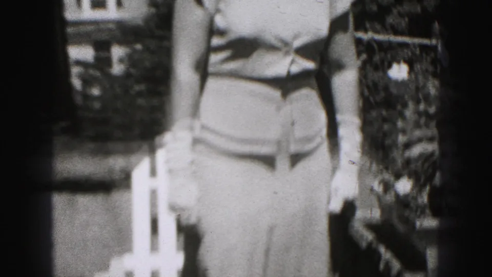 A woman in a light fitted dress stands partly cropped near greenery and white outdoor fencing in Harrisburg, Pennsylvania archival footage.