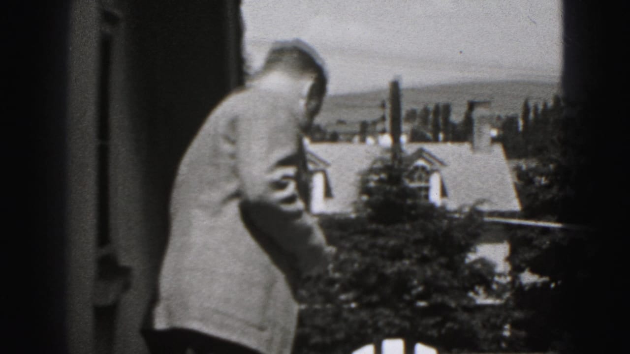 Adult man in a light suit stands on an upper patio in Harrisburg, Pennsylvania, with residential rooftops in the background.
