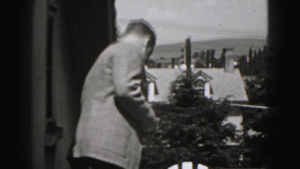 Adult man in a light suit stands on an upper patio in Harrisburg, Pennsylvania, with residential rooftops in the background.