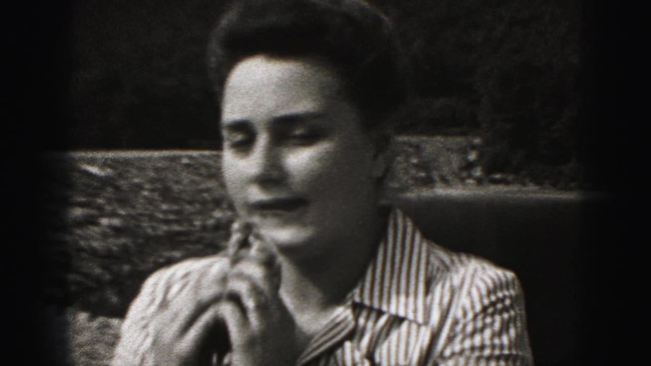 Woman in a striped shirt wipes her nose with a handkerchief outdoors.