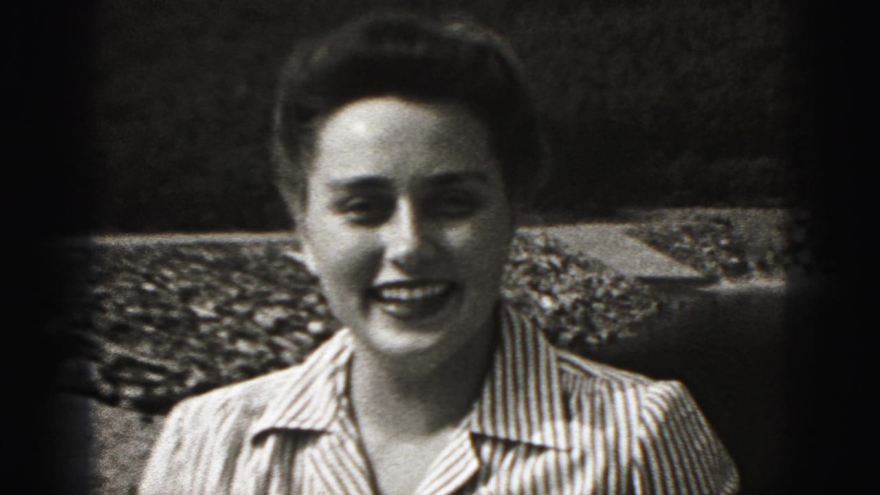 A woman in a striped collared shirt smiles toward the camera in the 1975 Harrisburg home-movie setting.