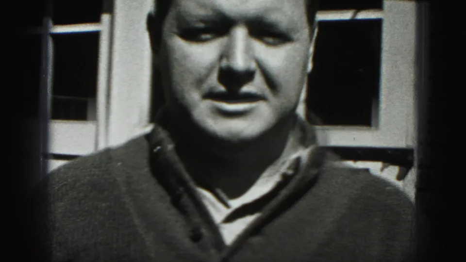 Close home-movie view of the adult man's face and sweater against the garage door in Harrisburg, Pennsylvania, 1975.