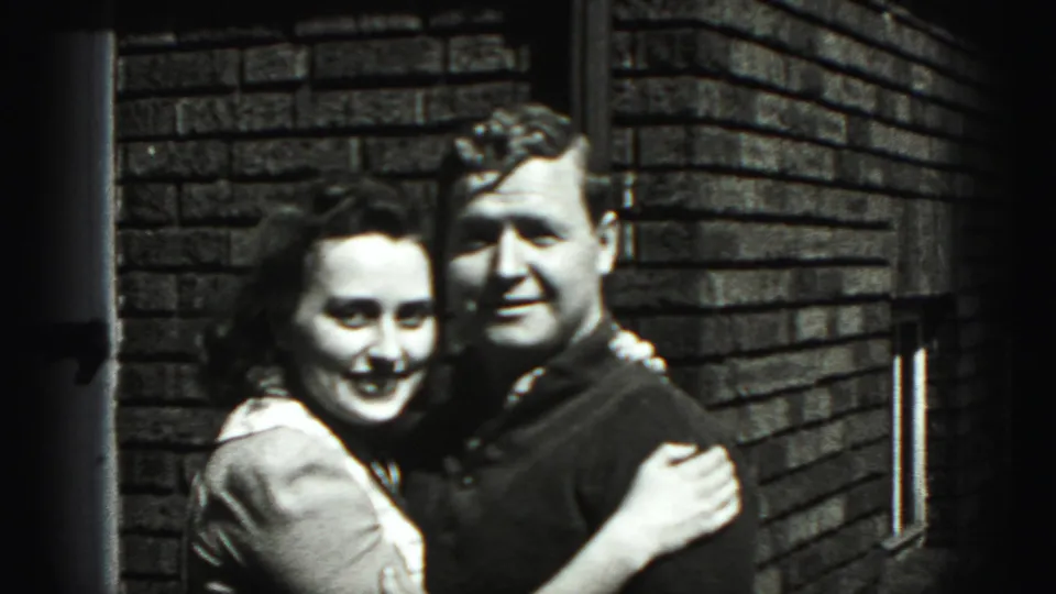 The young couple stands arm in arm and smiles toward the camera outside a brick building in Harrisburg, Pennsylvania.