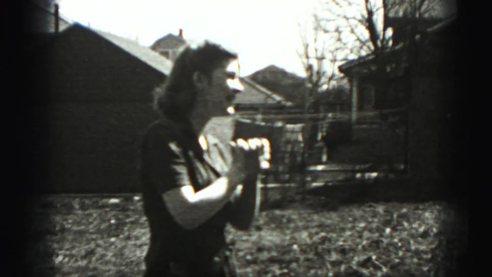 The woman appears in side profile with hands clasped, standing in a sunlit residential yard in Harrisburg, Pennsylvania.