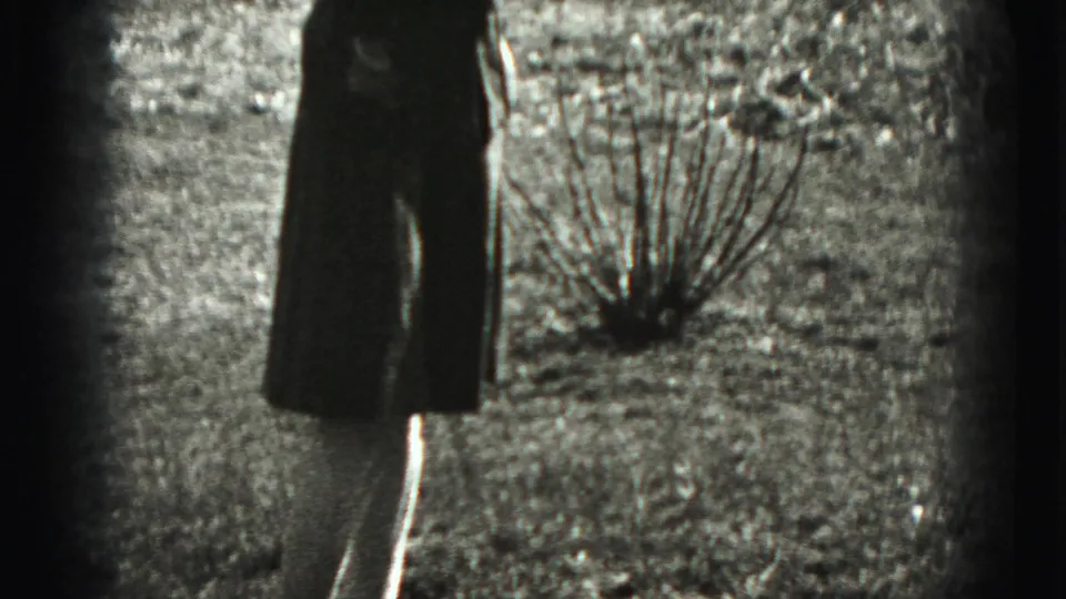 A side view shows the woman in the Harrisburg backyard, hands near her chest, with houses and small leafless shrubs behind her.