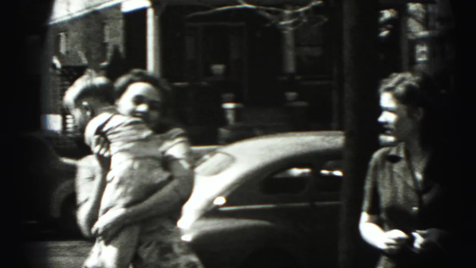 A woman in a patterned dress faces the camera during a candid 1975 Harrisburg sidewalk interaction.