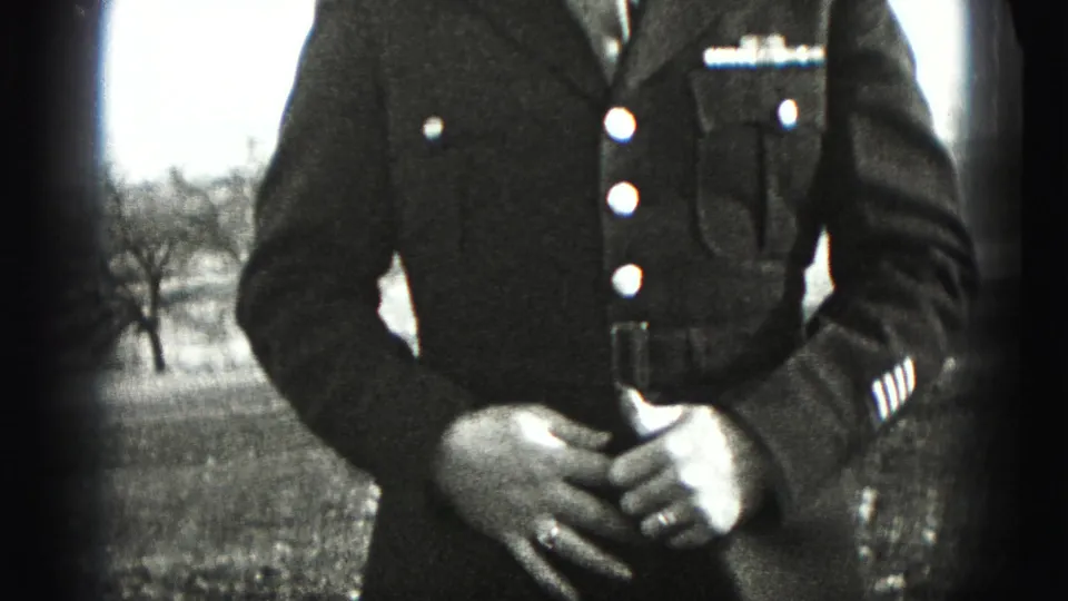 A man in a formal military uniform stands outdoors in Harrisburg, Pennsylvania, with insignia, buttons, sleeve stripes, and clasped hands visible.