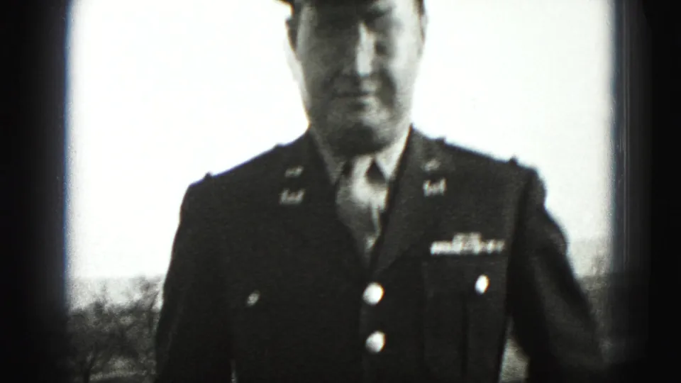 In 1975 Harrisburg home-movie footage, a uniformed adult man stands close to the camera with his face partly soft and overexposed.