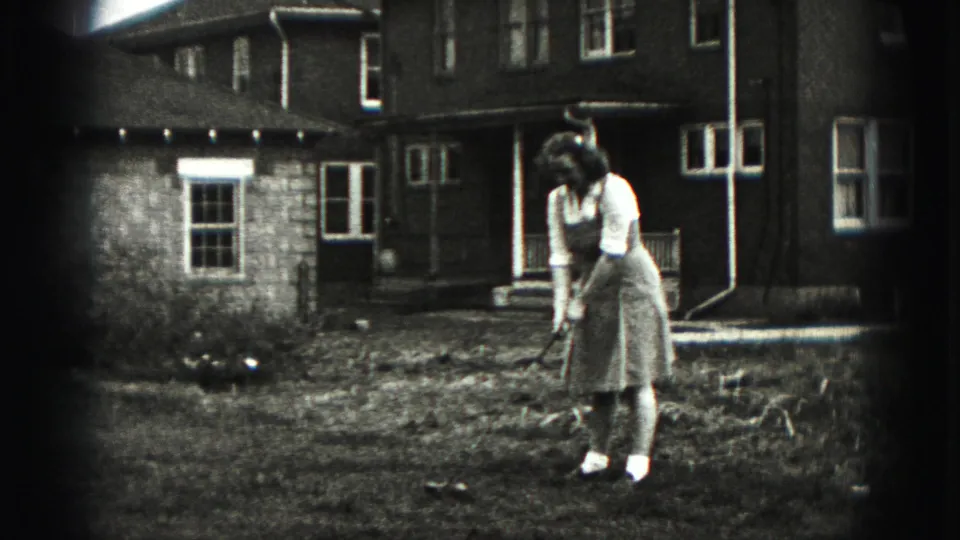 The woman resets her stance with the golf club in a Harrisburg backyard, with the residential exterior still visible.