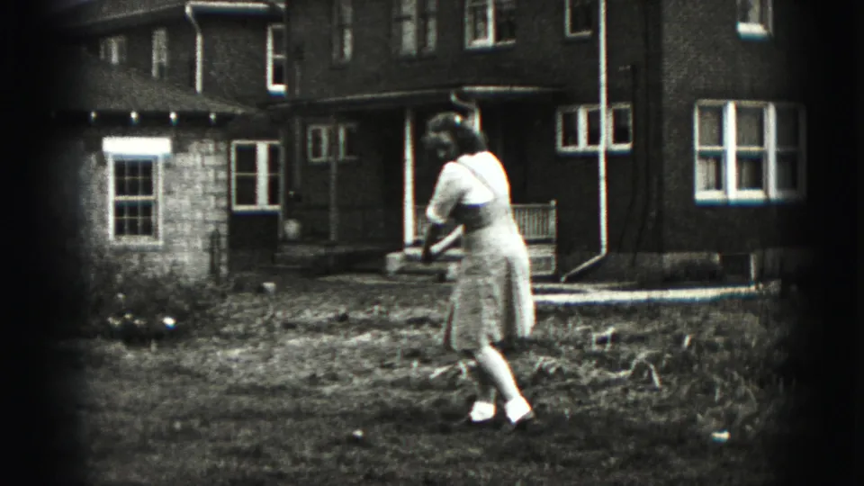 The 1975 Harrisburg home movie shows the woman turning into her golf swing in the backyard area.