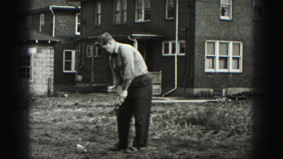 In Harrisburg, Pennsylvania home-movie footage, a man addresses a golf ball in a yard outside a brick house.