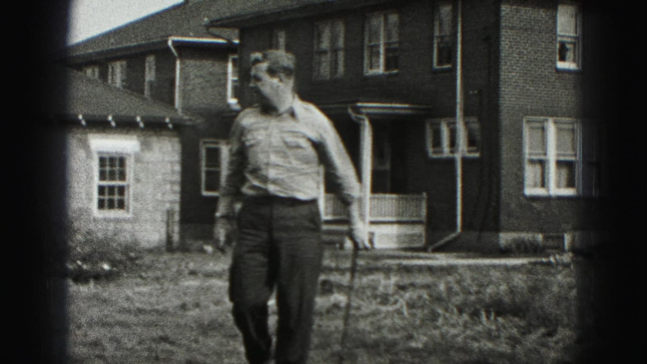 The man moves through the yard with a golf club beside a brick residential building in the 1975 Harrisburg footage.