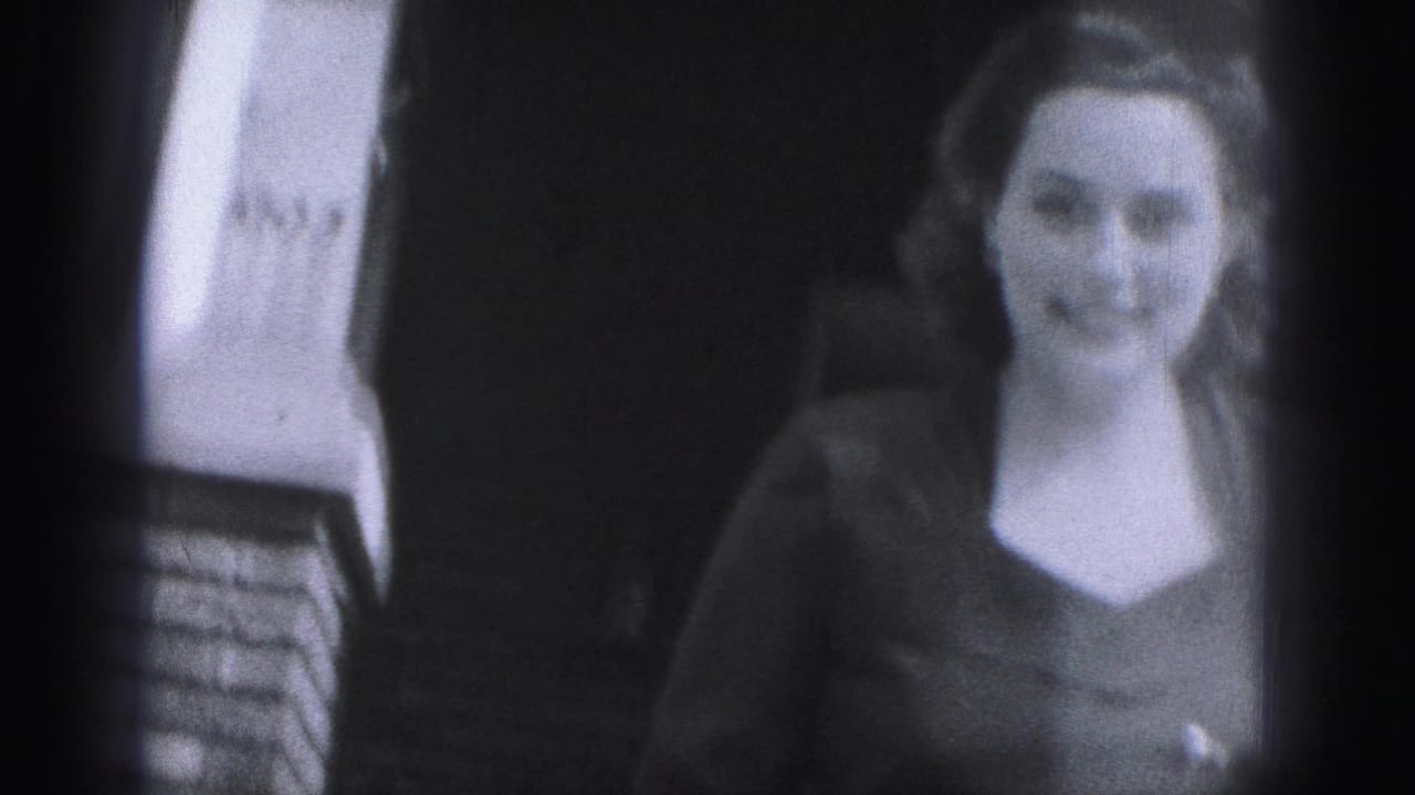 Woman standing on brick steps outside a building and smiling toward the camera.