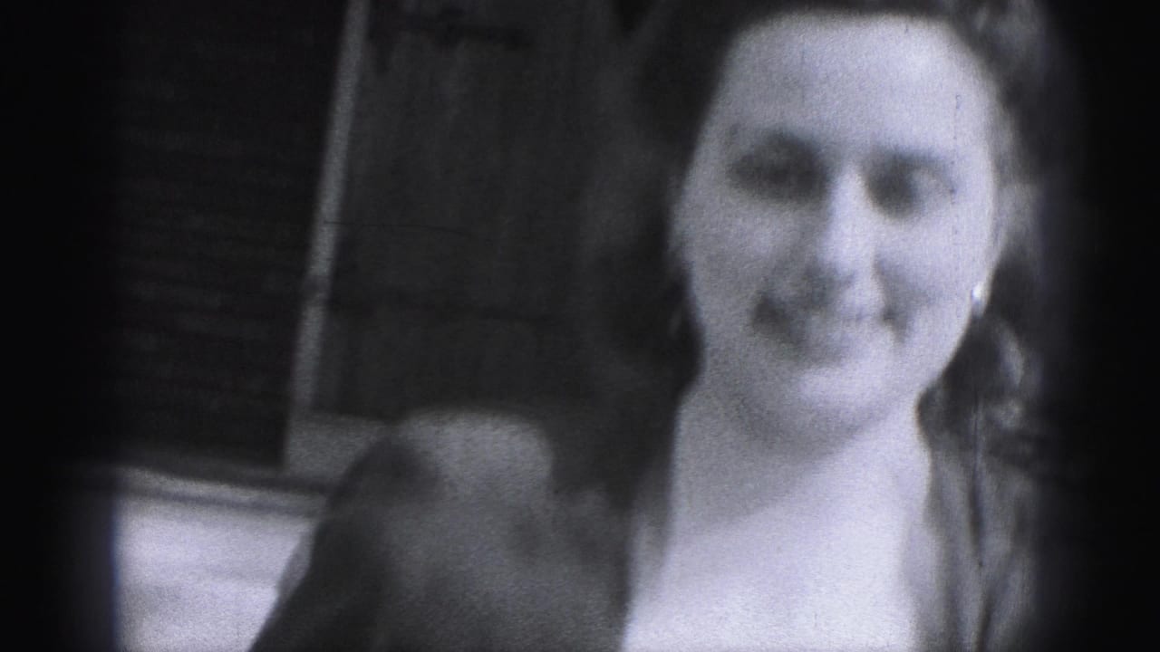 A closer 1975 Harrisburg frame shows the woman smiling near the brick exterior and entrance area.