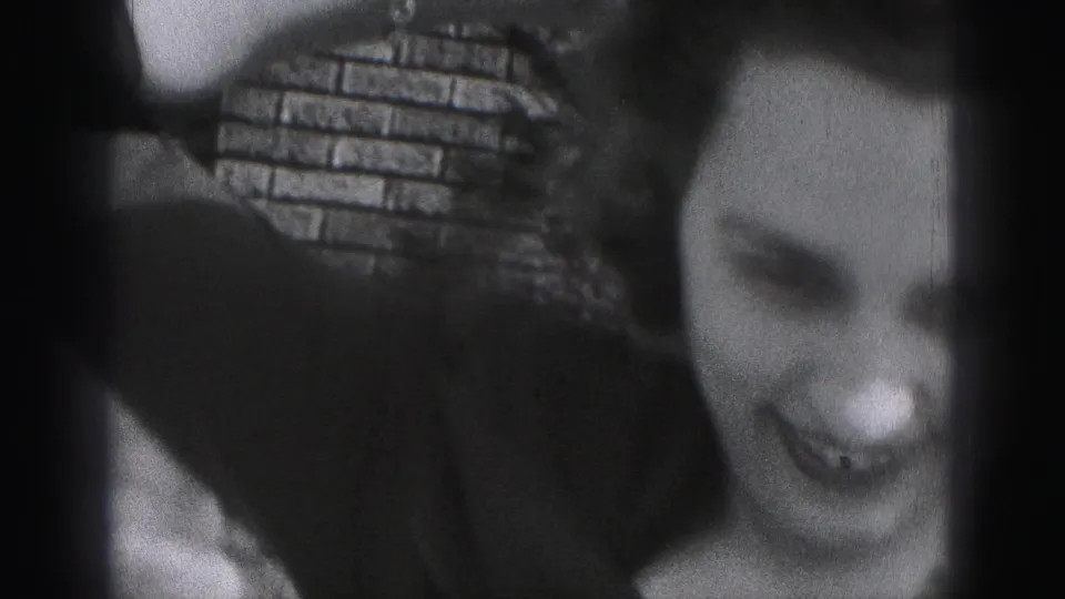 The final 1975 Harrisburg frame is a very close, soft-focus view of the woman laughing with brickwork behind her.