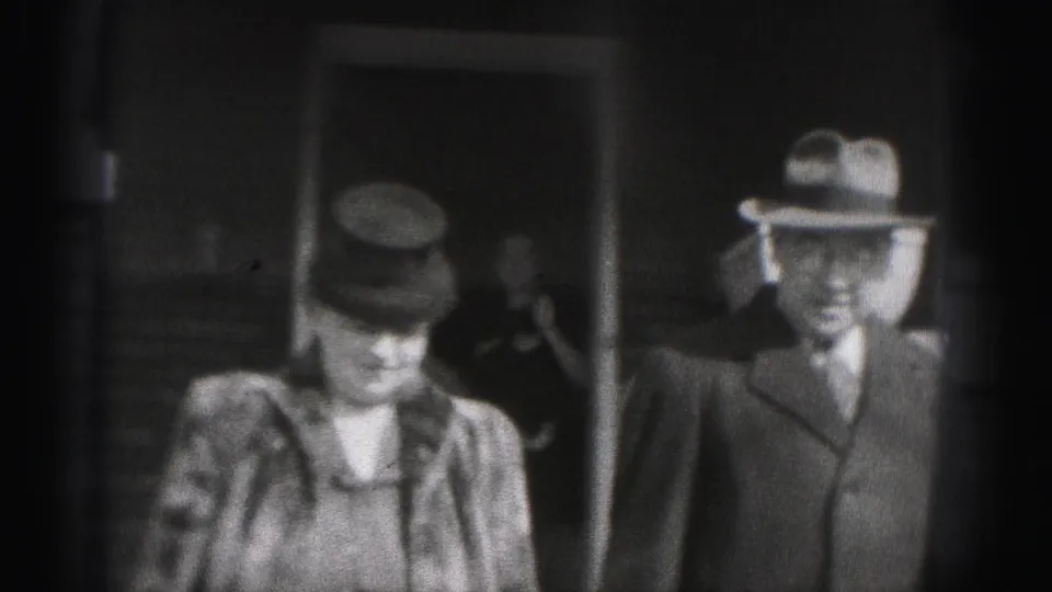 The Harrisburg 1975 frame shows a woman in a hat and coat near a suited man outside a building entrance.