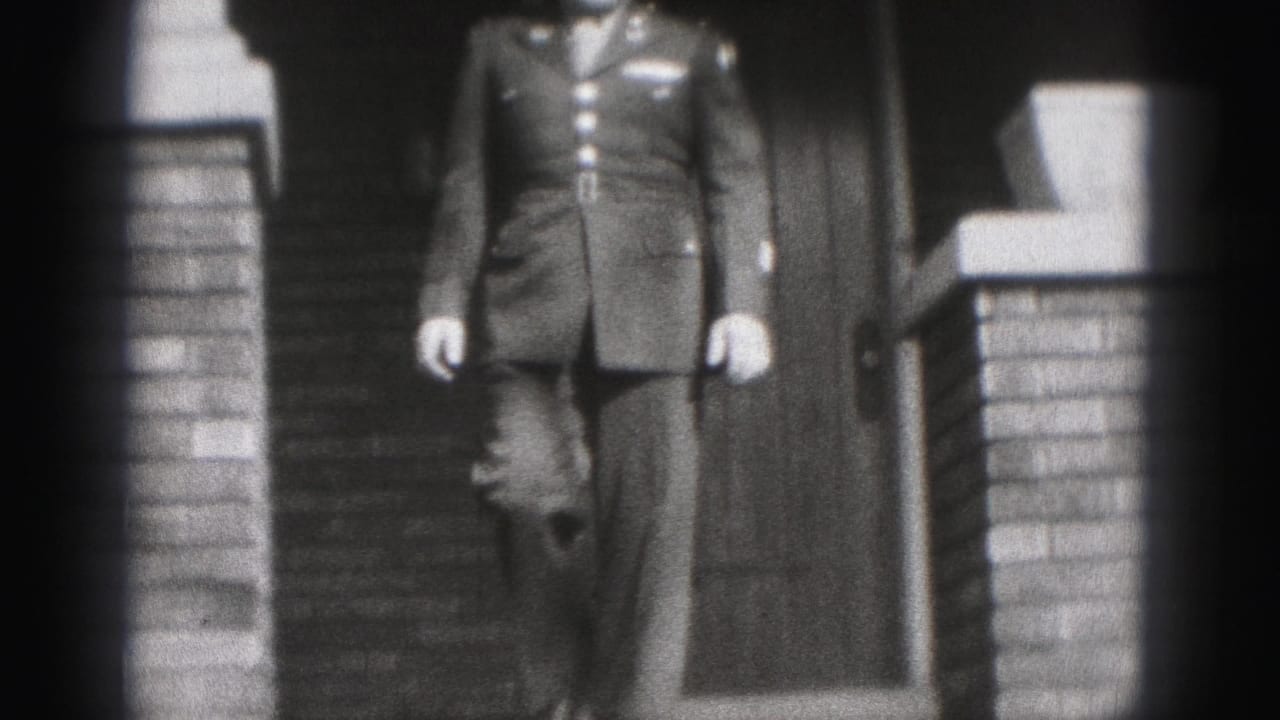 Uniformed man begins descending porch steps between brick columns.