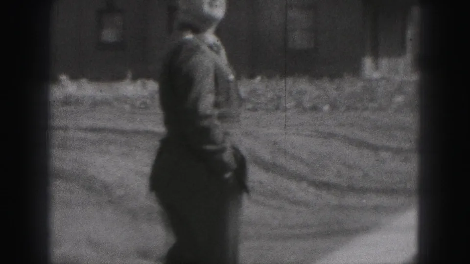 A side view shows the uniformed man walking across a yard in the Harrisburg residential setting captured on 8mm film.
