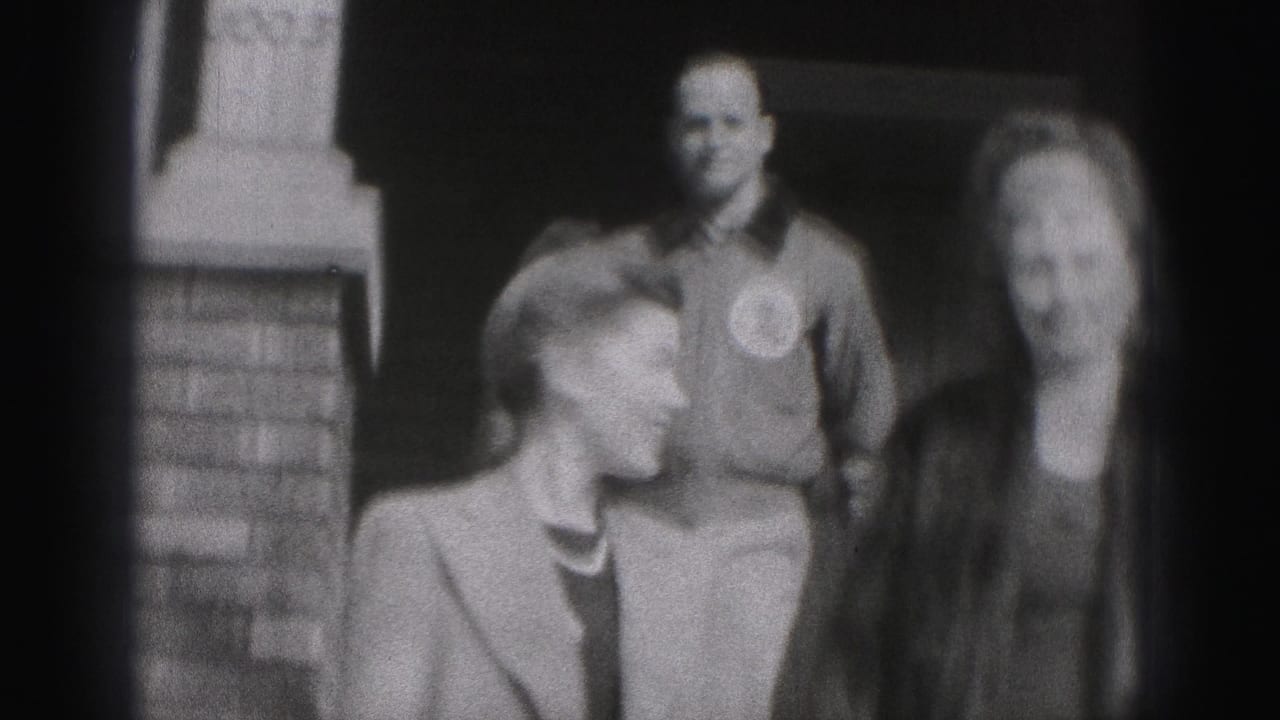 Two women and a man stand together outside a building in the Harrisburg 1975 home-movie scene.