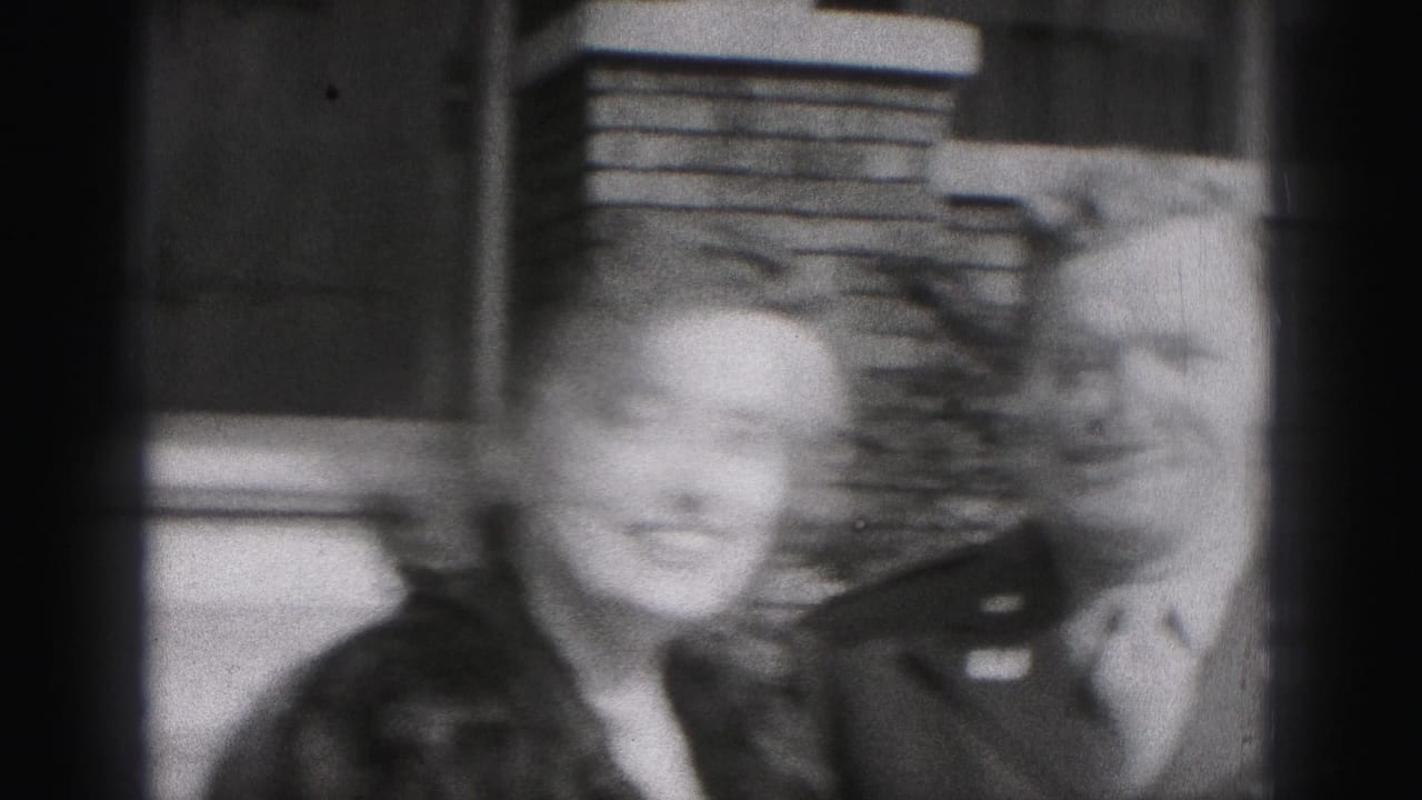 The woman smiles close to the camera while the uniformed man stands beside her outside a Harrisburg residence.