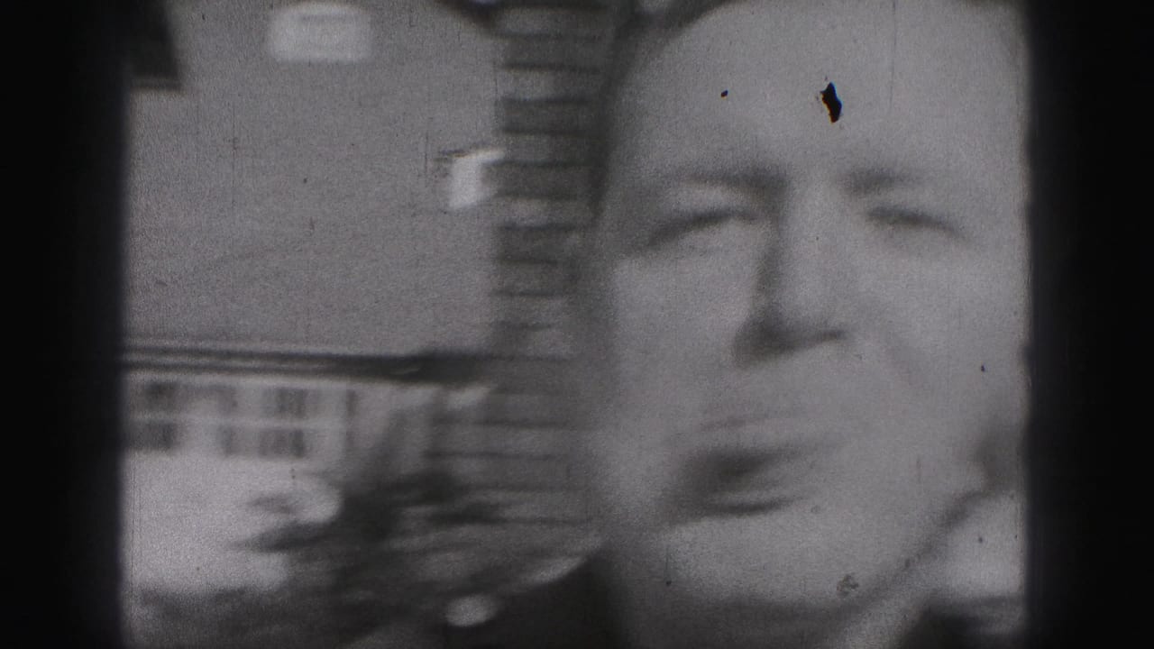 In 1975 Harrisburg home-movie footage, a uniformed man leans close to the camera and sticks out his tongue outside a brick house.