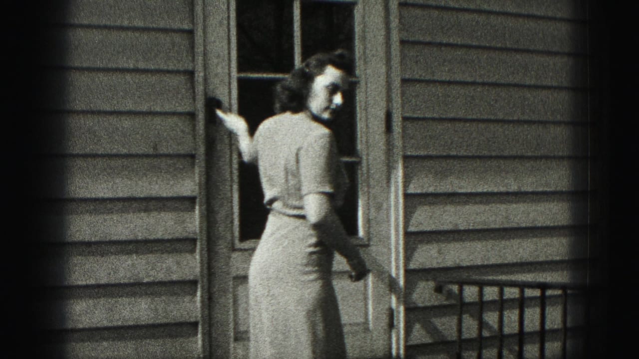Woman turns at the doorway while holding or closing the door behind her.
